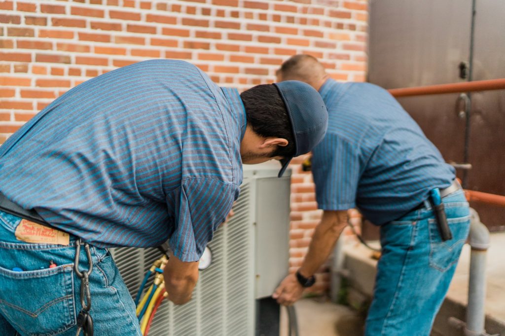 View behind Jacob HAC employees as they work on an outdoor HVAC unit