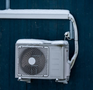 Outdoor HVAC unit covered in snow