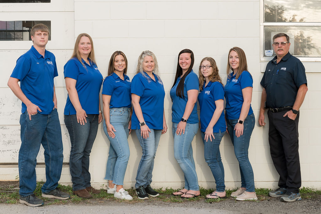 Eleven Jacob Heating & Air Conditioning employees standing in front of a white garage door