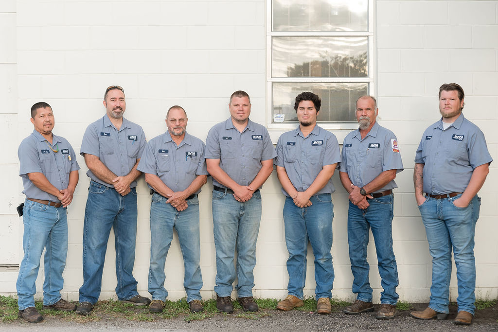 Jacob Heating & Air Conditioning employees standing in front of a garage door
