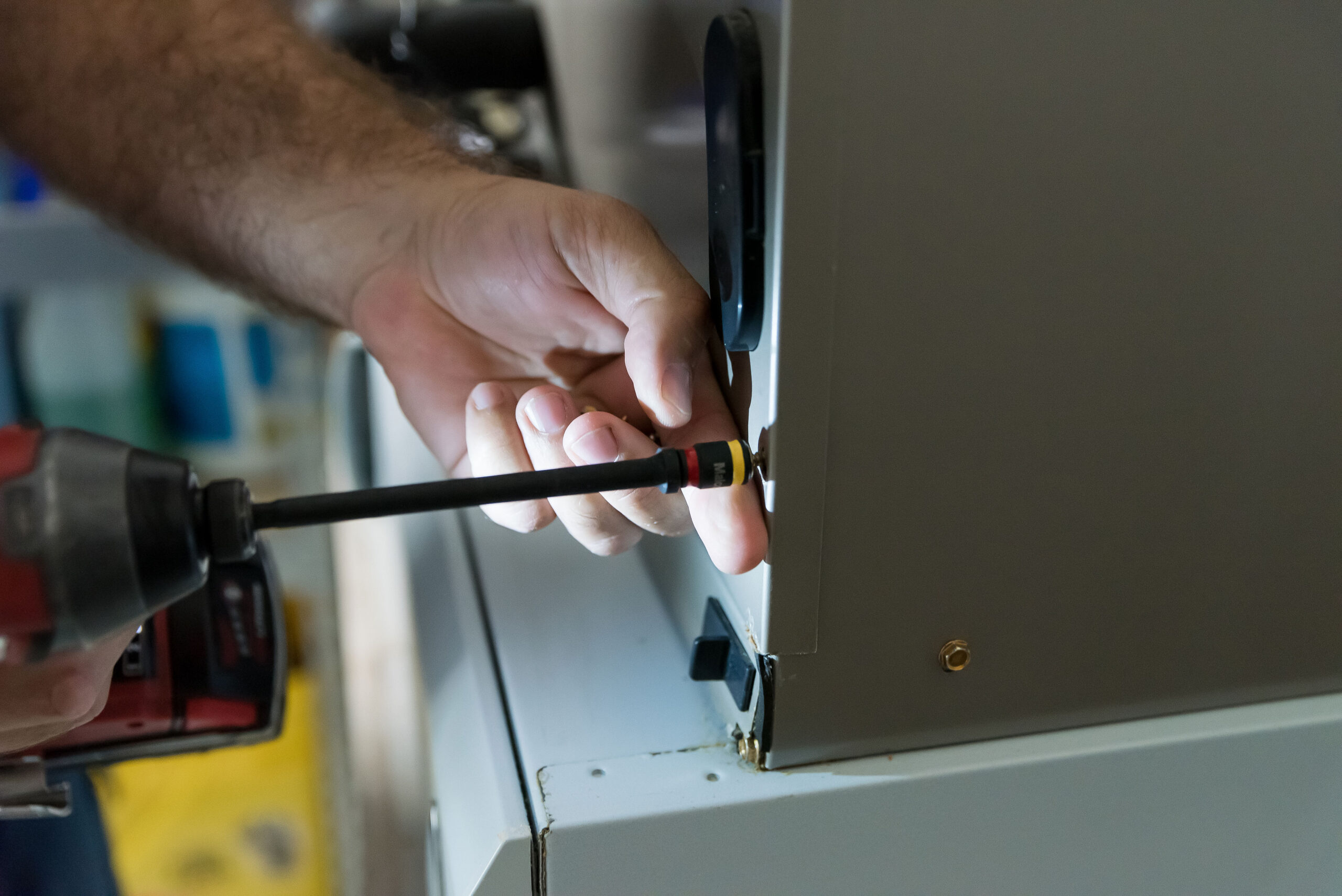 A service technician screwing in a boiler panel.