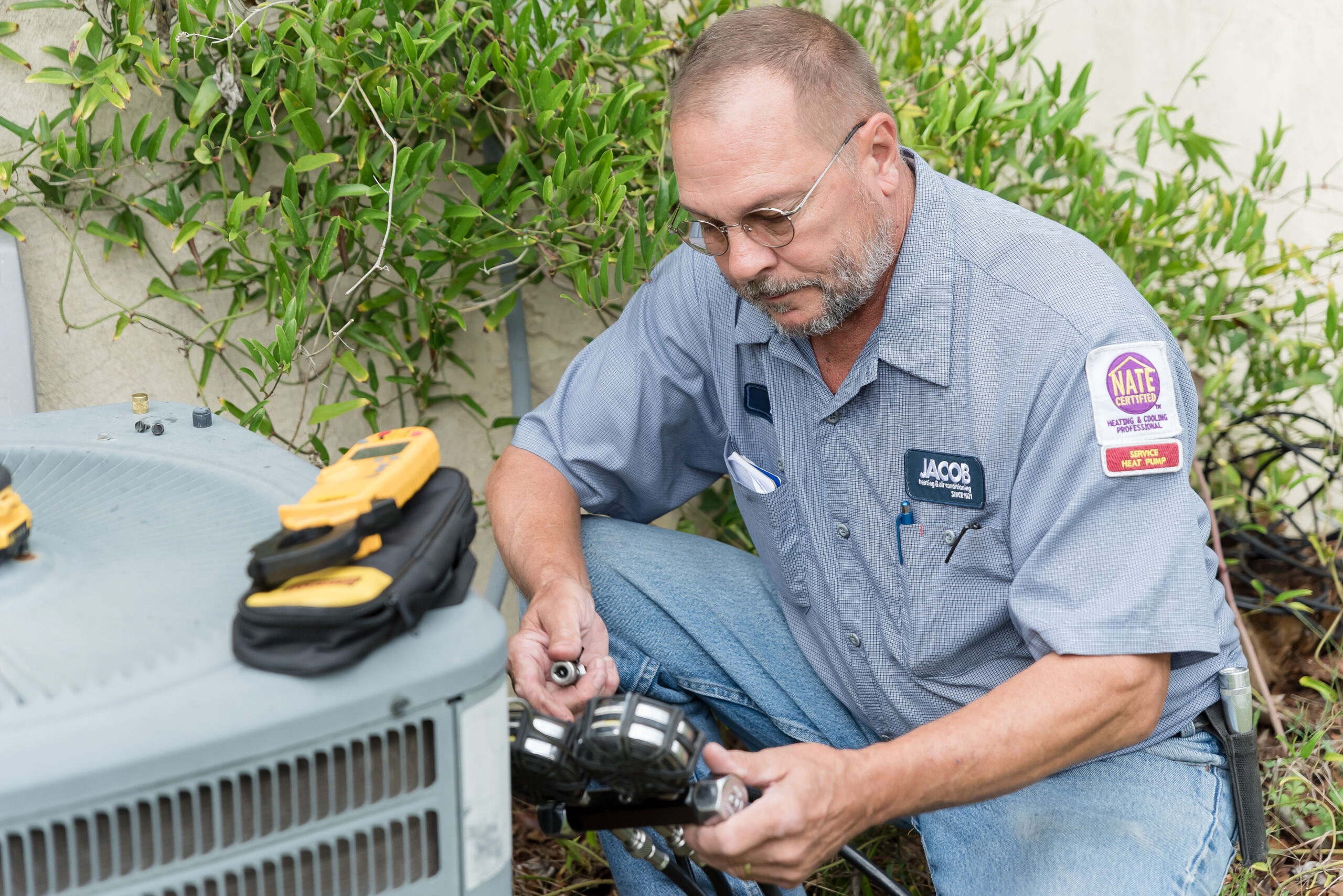 Technician testing an air conditioning unit outside.